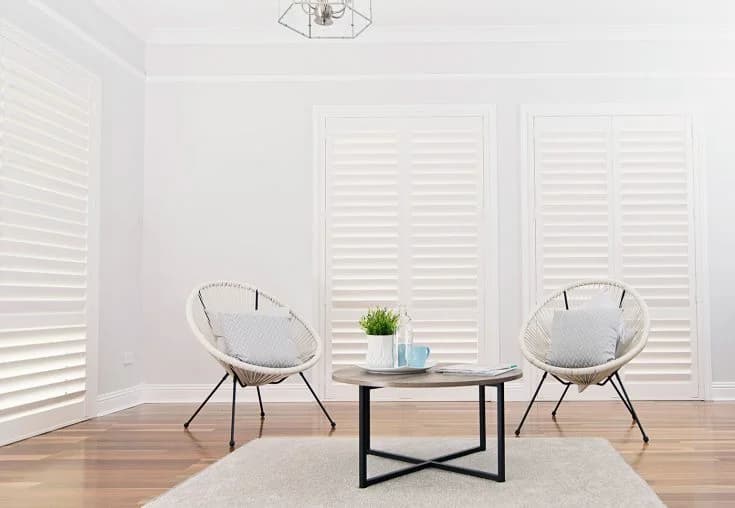 TWO Highprofile Classic interior wood shutters in a bright sitting room