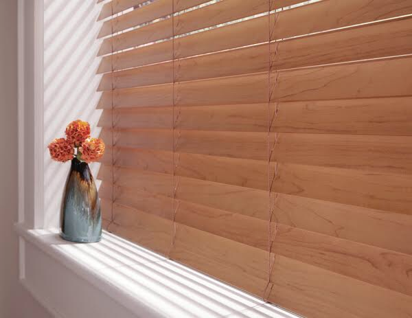 Close-up of natural wood blind slats with warm afternoon light and shadow casting across their surface