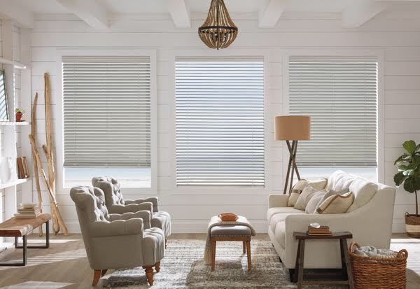 Faux wood composite blinds in a bright coastal farmhouse living room, showing moisture-resistant and durable construction for Northern Idaho homes
